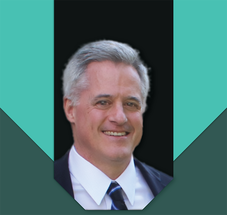 Burt Hurlock smiling in a formal suit and tie.