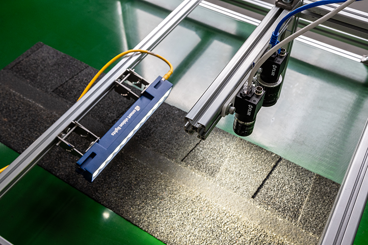 Zetamotion inspection lab setup analyzing a roofing shingle sample with dual cameras and lighting.