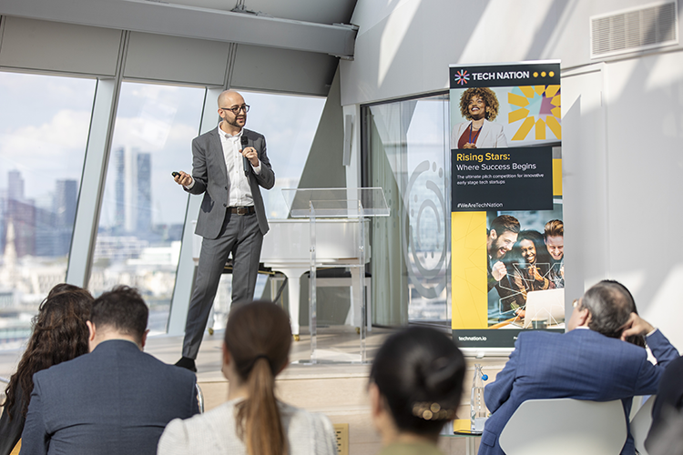 Wilhelm Klein speaking on stage at Tech Nation Rising Stars event in London, addressing an audience in a modern conference space.